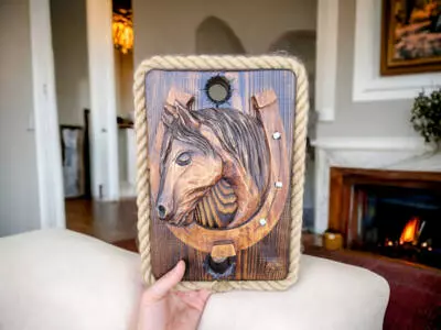 Koń rzeźbiony z podkową na desce -  ozdoba z drewna