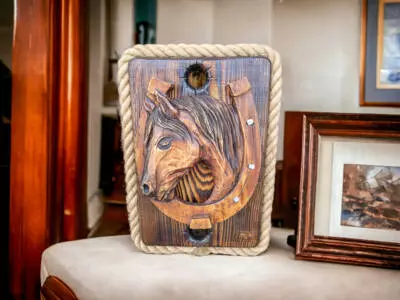 Koń rzeźbiony z podkową na desce -  ozdoba z drewna